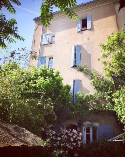 un bâtiment avec des fenêtres sur son côté dans l'établissement Au Puits de la Fontaine, à Tavernes