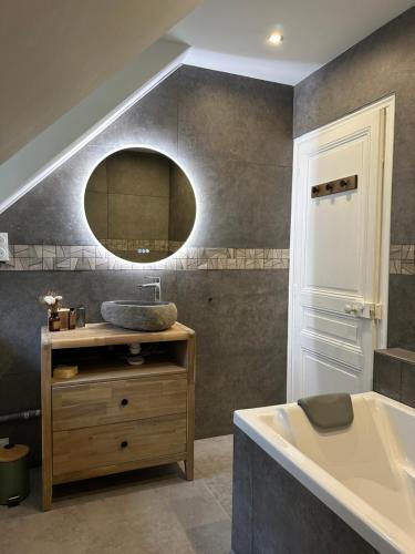 une salle de bain avec un lavabo, une baignoire et un miroir dans l'établissement Le Magnolia Maison 12 Couchages, à Dieppe