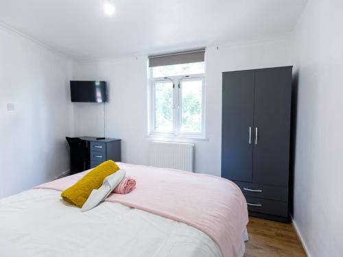 a bedroom with a large bed and a black cabinet at Inviting 3-Bed House in London stay up to 6 in London