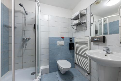 ein Bad mit einem WC, einem Waschbecken und einer Dusche in der Unterkunft Kurhotel Brussel in Franzensbad