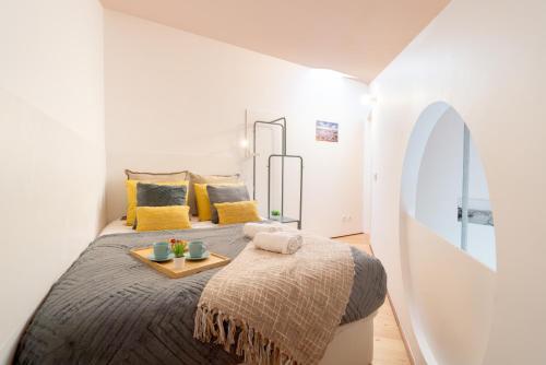 ポルトにあるHost Wise - Quiet Colourful House - Gardenのベッドルーム1室(大型ベッド1台、トレイ付)