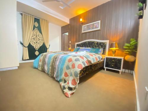 a bedroom with a bed with a colorful comforter at Viceroy Royal Hotel Apartment Islamabad in Islamabad