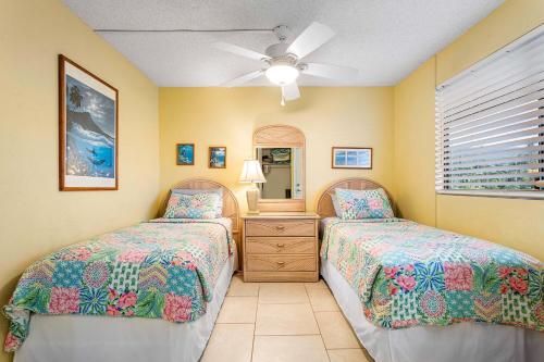 a bedroom with two beds and a ceiling fan at White Sands Village#213 in Kailua-Kona