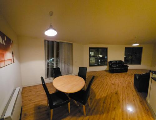 sala de estar con mesa de madera y sillas en Penthouse Apartment en Kilkenny