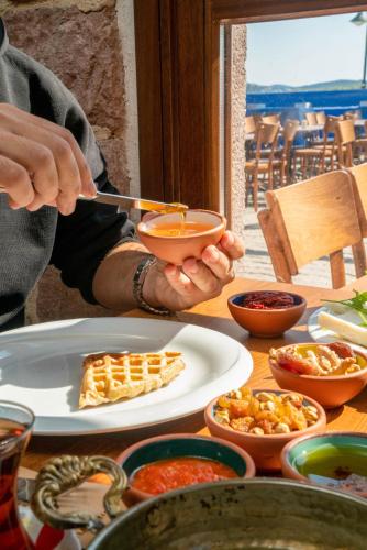 a person holding a bowl of food on a table at Cunda Taka in Ayvalık