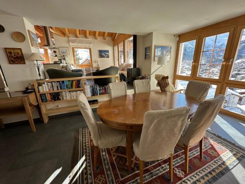 a dining room with a wooden table and chairs at Modern self-catering apartment with Matterhorn views in Zermatt
