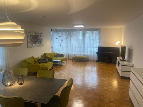 uma sala de estar com um sofá, uma mesa e um piano em Köln Zentrum - Top Wohnung für 8 Personen em Colônia