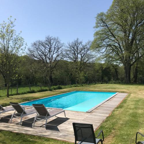 une piscine avec deux chaises et une terrasse dans l'établissement Le logis du château la Flocellière, à Sevremont