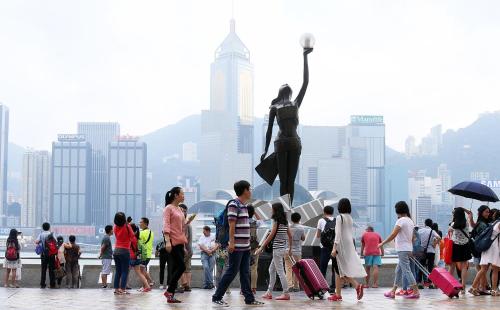 een menigte mensen die voor een standbeeld lopen bij International Inn in Hong Kong