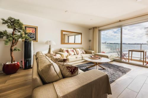 un salon avec un canapé et une table dans l'établissement BLUE UHAINA KEYWEEK Sea view apartment Biarritz downtown, à Biarritz