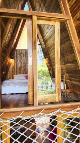 Pokój z łóżkiem i dużym oknem w obiekcie Munduk Umah Cabin w mieście Munduk