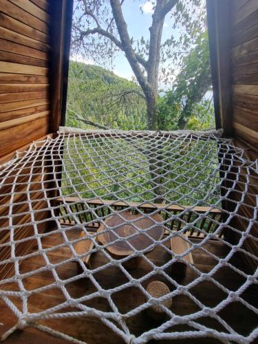 a hammock in a room with a window at Munduk Umah Cabin in Munduk