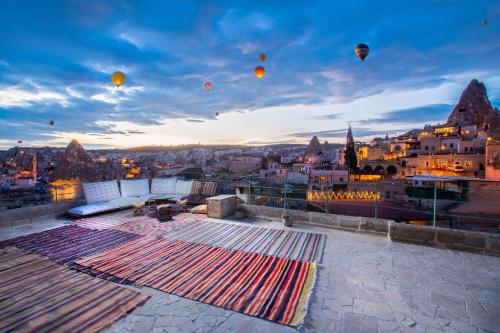 a group of hot air balloons flying over a city at Terra Cave Hotel in Goreme