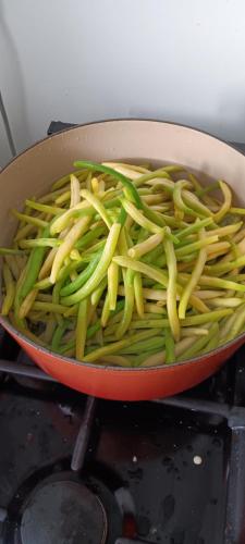a pan filled with green beans on a stove at Le Domaine d'Élise Chambres et table d'hôtes - Vosges in Saint-Ouen-lès-Parey