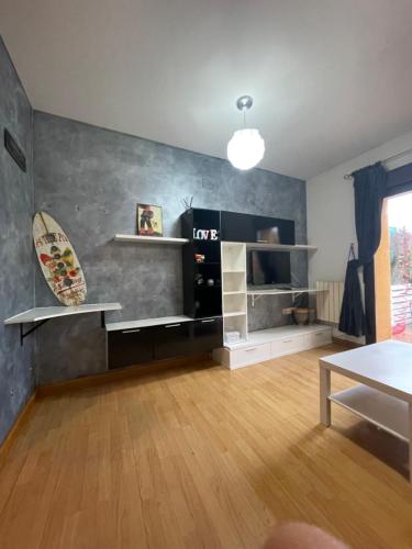 a living room with a surfboard on the wall at La Marquesa de Vallespin .Patio.Centro ciudad. in Avila