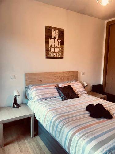 a bedroom with a large bed with a sign on the wall at La Marquesa de Vallespin .Patio.Centro ciudad. in Avila