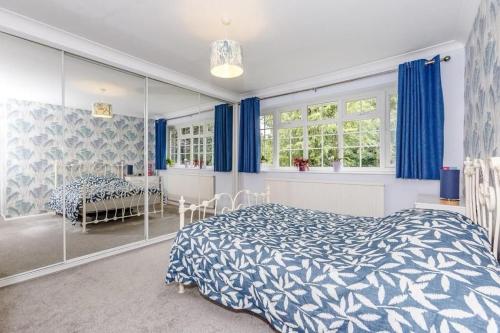 a bedroom with a blue and white bed and a table at Stunning 4-Bed House in Wetherby near York in Wetherby