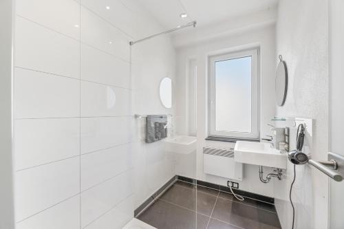 bagno bianco con lavandino e specchio di MONTEURWOHNUNG in Lorch RAUMSCHMIDE Apartments a Lorch