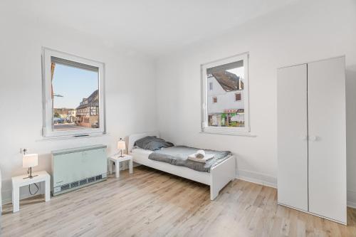 1 dormitorio blanco con 1 cama y 2 ventanas en MONTEURWOHNUNG in Lorch RAUMSCHMIDE Apartments, en Lorch