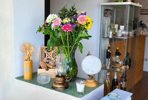 une table avec un vase de fleurs sur une étagère dans l'établissement Stella del Garda, à Lazise