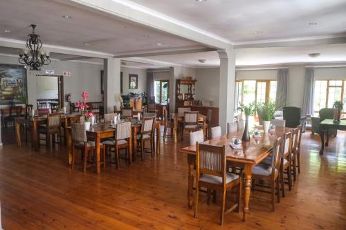 a dining room with wooden tables and chairs at The Kraal Addo in Addo