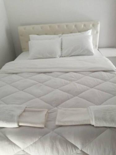 a large white bed with white sheets and pillows at Cozy Rodas House 2 in Politika