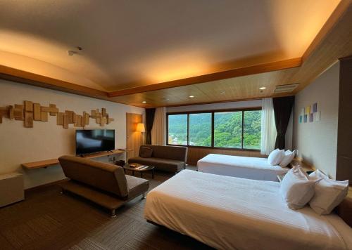 ein Hotelzimmer mit 2 Betten und einem TV in der Unterkunft Yuze Hotel in Kazuno