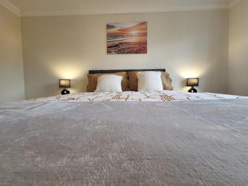 a bedroom with a large bed with two lamps at Rare Contemporary 5 Bed London Home 7min - Station in Surbiton