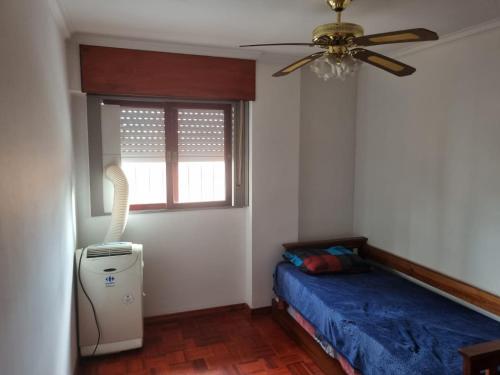 1 dormitorio con 1 cama, ventilador y ventana en Espacio Belgrano departamento centrico en Salta