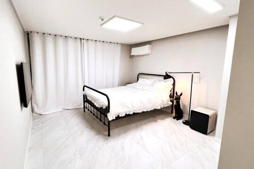 um quarto branco com uma cama e uma janela em Pet Friendly 305 em Suncheon