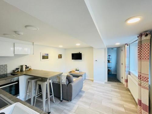 a kitchen and living room with a couch and a table at 10 Bromleys Court in Church Stretton