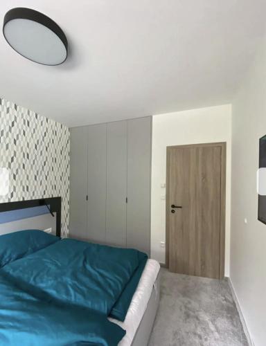 Un dormitorio con una cama azul y una puerta en Apartmán Alenka en Bystrá