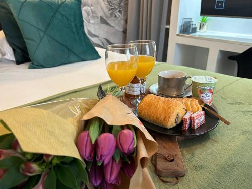 a table with a plate of food and drinks and flowers at Appart'TERRASSE - 20mn STADE U ARENA - CHAMPS ÉLYSÉES - RER A in Maisons-Laffitte