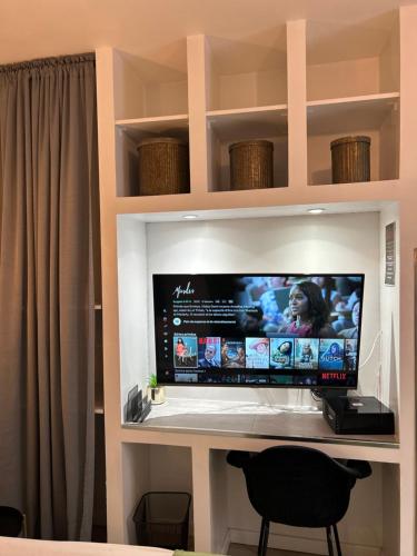 a flat screen tv sitting on top of a desk at Appart'TERRASSE - 20mn STADE U ARENA - CHAMPS ÉLYSÉES - RER A in Maisons-Laffitte