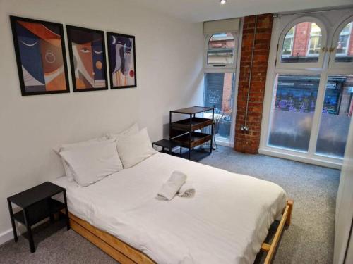 een slaapkamer met een bed met twee slippers erop bij Northern Quarter Flat in Manchester