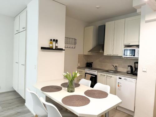 ロヴァニエミにあるCozy City Apartmentの白いキッチン(白いテーブルと椅子付)