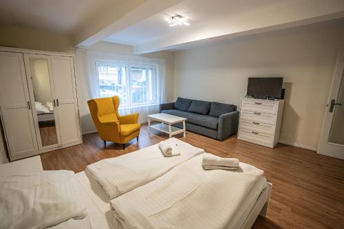 ein Schlafzimmer mit einem Bett, einem Sofa und einem Stuhl in der Unterkunft Gogol Apartment in Szeged