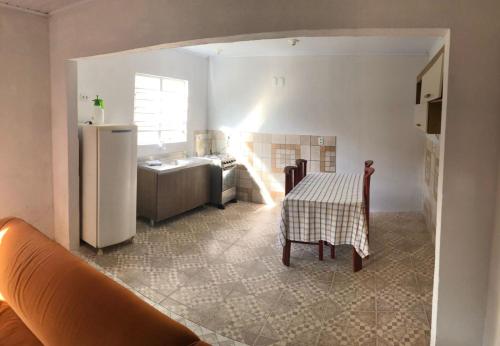 eine Küche mit einem Tisch und einem Kühlschrank in der Unterkunft Casa com 2 quartos grandes a 150m da praia in Rio Grande