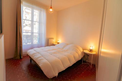 a large bed in a room with a window at Appartement cosy balcon Hypercentre in Manosque