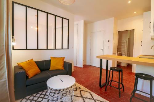 a living room with a couch and a table at Appartement cosy balcon Hypercentre in Manosque