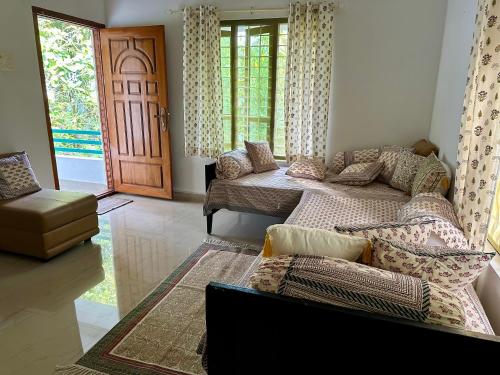 uma sala de estar com um sofá e uma porta em Swiss House By Keri em Varkala