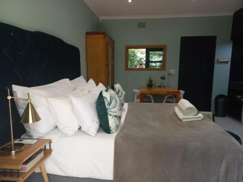 a bedroom with a large bed with white pillows at Lucano 1 Stellenbosch in Stellenbosch