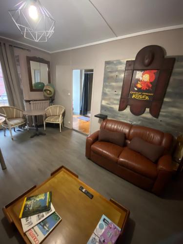 a living room with a leather couch and a table at COSY B&B in Murat