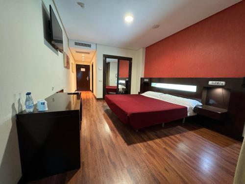 1 dormitorio con 1 cama y TV de pantalla plana en LA CANTUEÑA, en Madrid