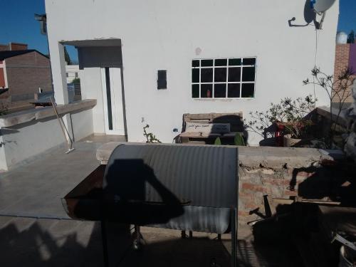 a shadow of a chair sitting on top of a roof at Lupita 3 in General Roca
