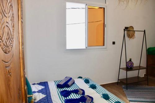 a bedroom with a bed and a window at TRAVEL SURF NATURE in Tamraght Ouzdar