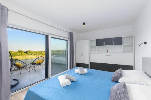 een slaapkamer met een blauw bed en een groot raam bij Villa Impression by Istrialux in Ližnjan