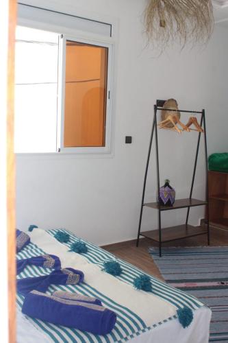 a bedroom with a bed with a mirror and a shelf at TRAVEL SURF NATURE in Tamraght Ouzdar