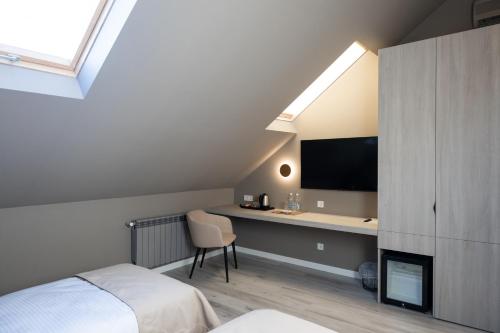 una camera con letto e scrivania con TV di R.HOTEL a Černivci