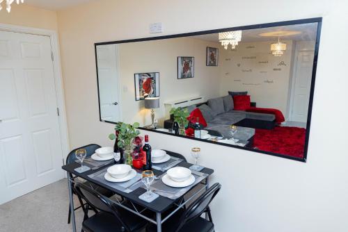 a dining room with a table with chairs and a mirror at 2ndHomeStays-West Bromwich- A Charming 2-Bedroom Maisonette in West-Midlands, Suitable for long Stay Contractors-Families-Group of Friends on Holiday, 10 mins to J1 M5 and 24 mins to Birmingham in West Bromwich